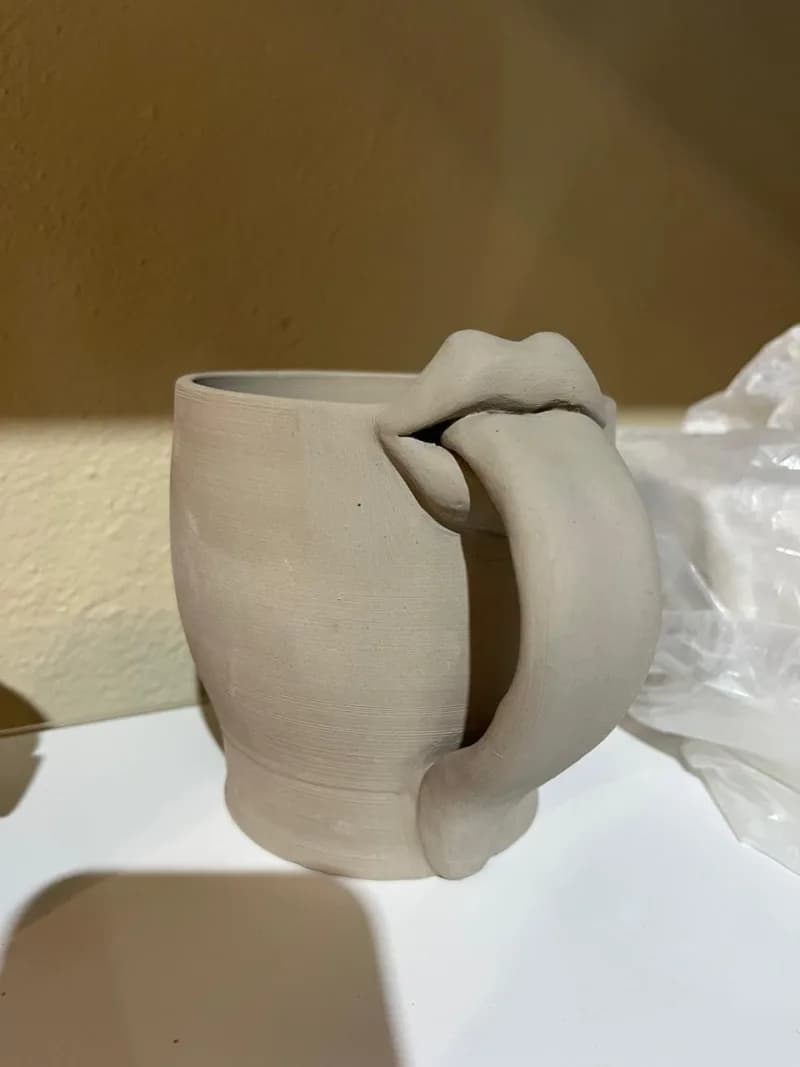 Mug with sculpted lips handle in raw clay