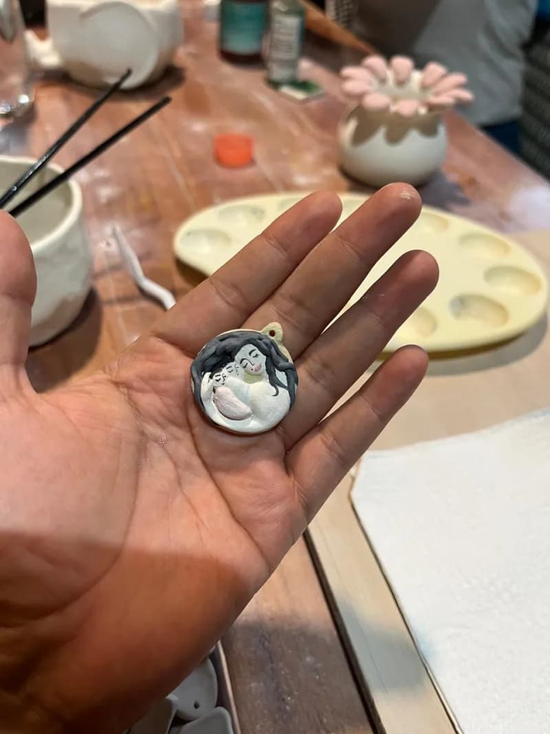 Hand holding small ceramic pendant